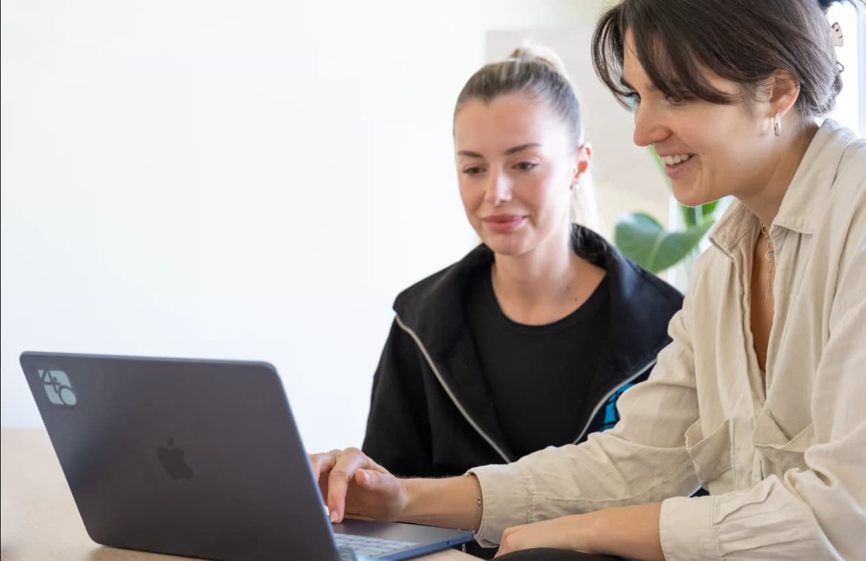 Therapeutin und Patientin gemeinsam am Laptop in der Praxis Vier Punkt Null Hamburg-Lokstedt — gemeinsame Terminplanung in heller Atmosphäre.