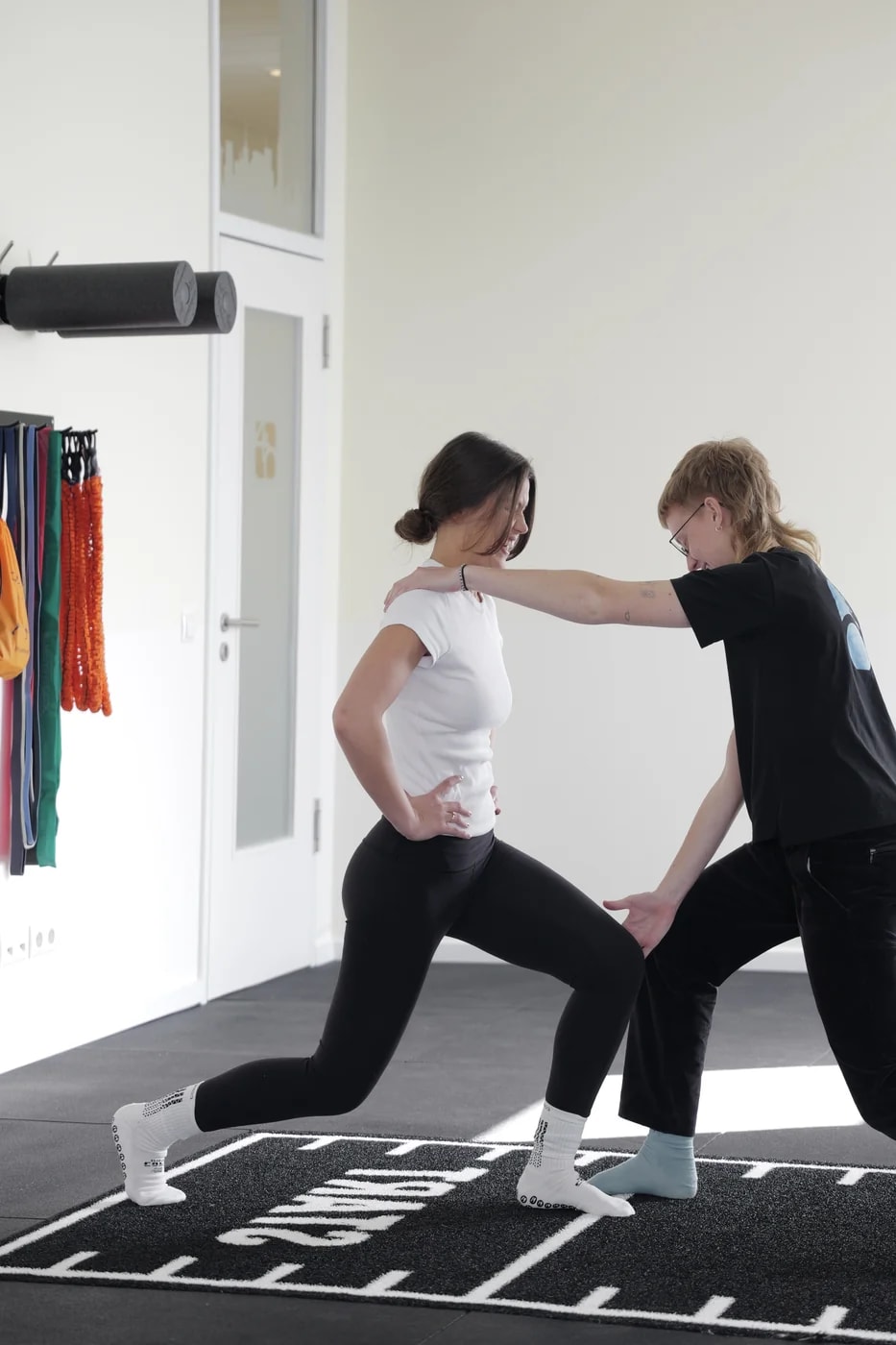 Trainingsraum-Detail mit Therapeutin und Patientin — Praxis Vier Punkt Null Hamburg.