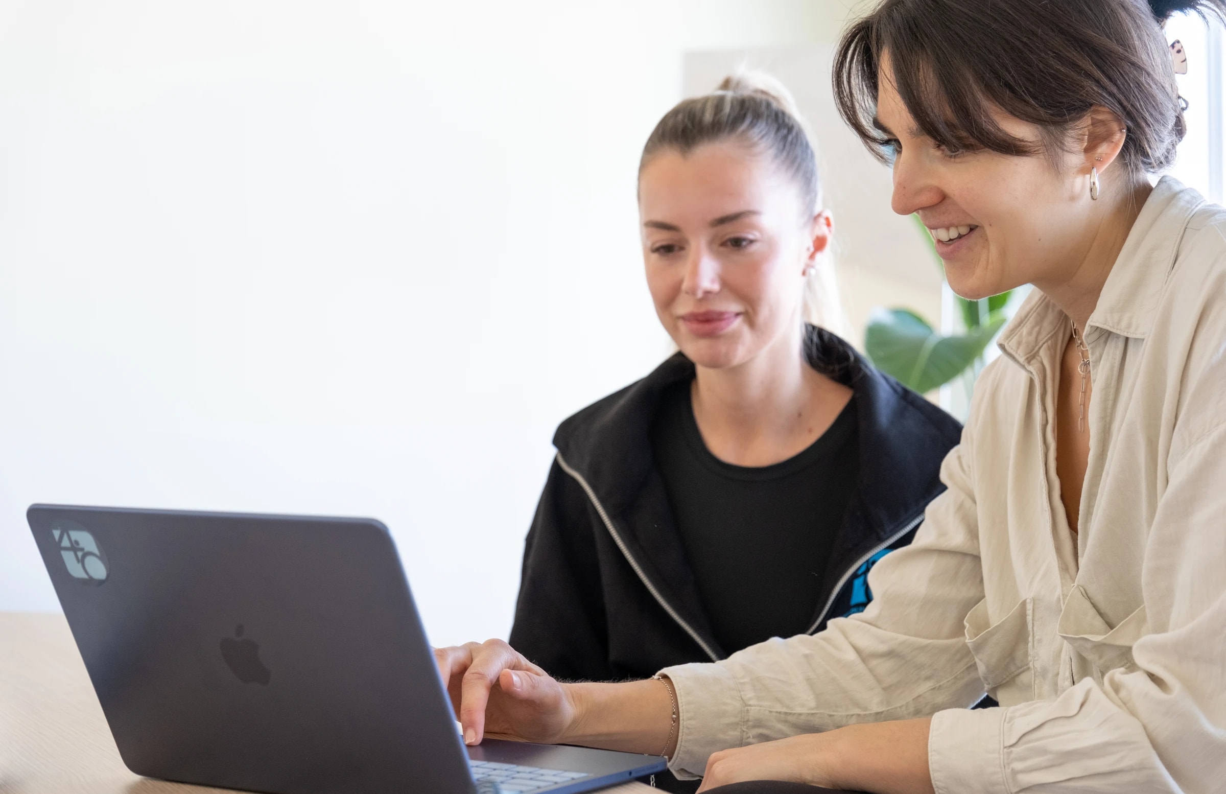 Therapeutin und Patientin gemeinsam am Laptop in der Praxis Vier Punkt Null Hamburg — gemeinsame Terminplanung in heller Atmosphäre.